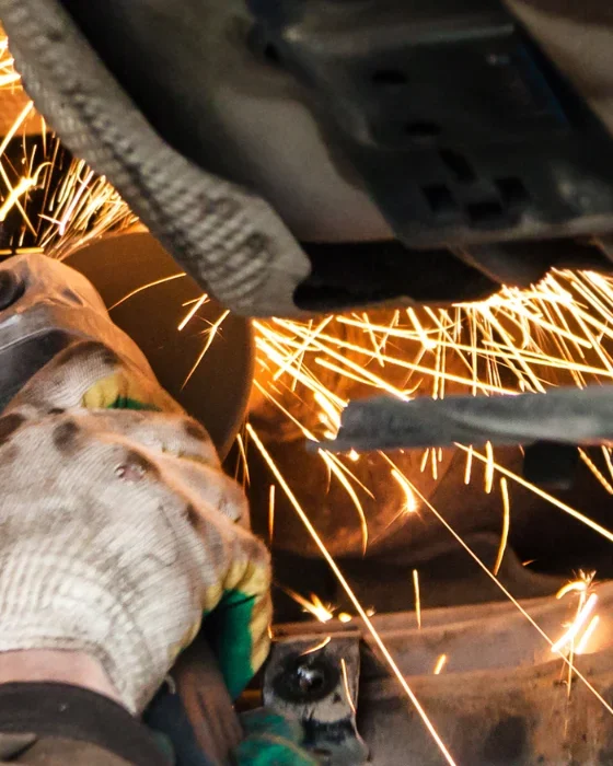 Mechanic Cleans Muffler Pipe
