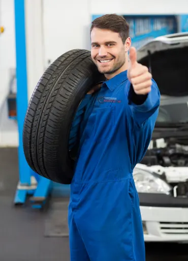 Mechanic holding a tire wheel at the repair garage